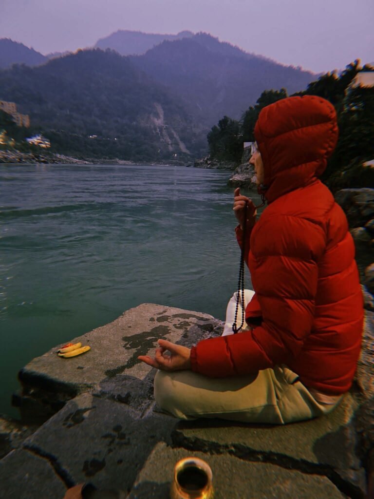 Early morning meditation by the sacred river Ganga to start the day during a 14-day spiritual yoga retreat